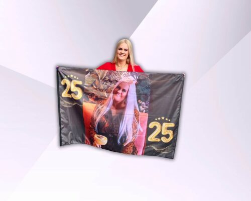 Grote persoonlijke verjaardagsvlag met foto van de jarige, vastgehouden door de jarige zelf.