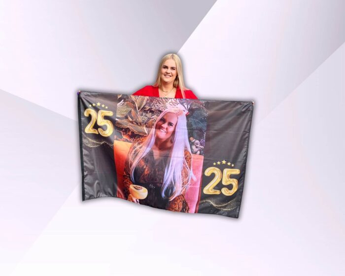 Grote persoonlijke verjaardagsvlag met foto van de jarige, vastgehouden door de jarige zelf.